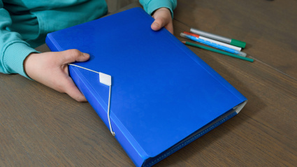 Imagen de recurso de un niño con una carpeta del colegio
