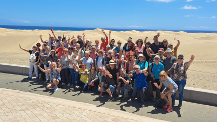 Grupo grande de turistas con un guía turístico en las dunas de Maspalomas