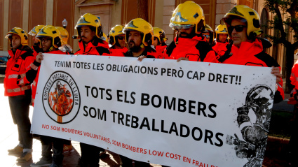 Algunos de los bomberos voluntarios sosteniendo una pancarta