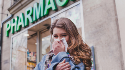 FWWNPY sick cold woman next to a pharmacy, flu concept, buy medicaments