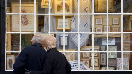 Imagen de recurso de un matrimonio de personas mayores frente al escaparate de una tienda