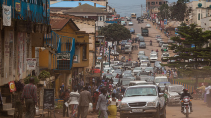 Bukavu, República Democrática del Congo: Tráfico en una polvorienta calle central de la ciudad. Coches y motos.