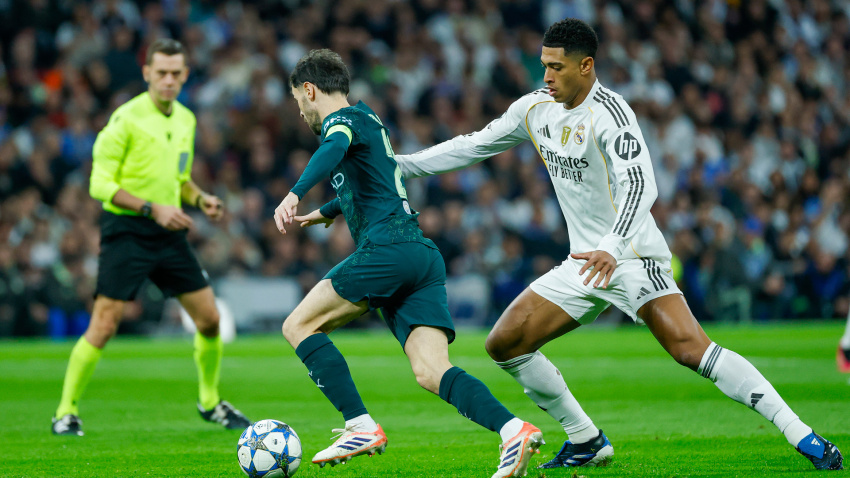 Bernardo Silva trata de conducir el balón en presencia de Jude Bellinghan en un momento del Real Madrid - Manchester City