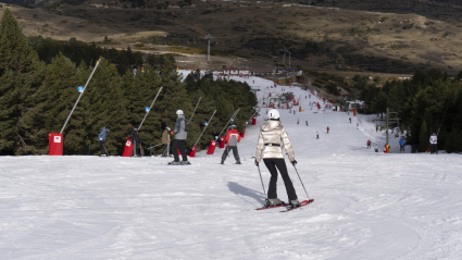 Varios aficionados disfrutan de la nieve durante la apertura de pistas de la estación de Valdelinares, en Teruel