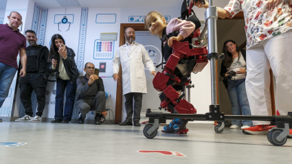 La pequeña de 6 años con parálisis cerebral Gala ha sido la protagonista de la presentación este lunes del primer exoesqueleto pediátrico que se ha incorporado al Hospital Universitario Insular-Materno Infantil de Gran Canaria. En la imagen, Gala da los primeros pasos en presencia, entre otros, del presidente de Canarias, Fernando Clavijo (d), la consejera de Sanidad, Esther Monzón, y los responsables médicos del hospital. EFE/Ángel Medina G.