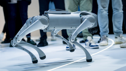 Un perro robot paseando y jugando entre la gente en una feria tecnológica