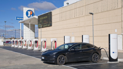Una toma estática de un Tesla Model 3 negro sólido con motor dual cargándose en el supercargador V4 de Salamanca.