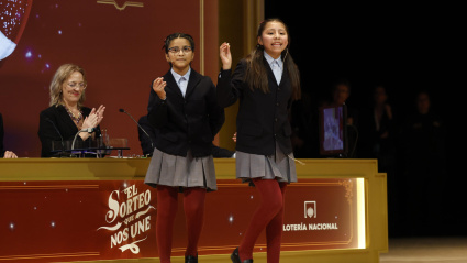 Alba Yadira Machaca (d) e Italy Andrea Blanco cantan el número agraciado con el premio gordo del Sorteo de la Lotería de Navidad, dotado con 4 millones de euros a la serie