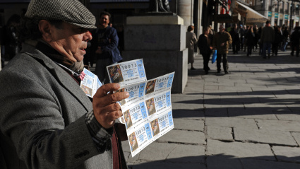 Un hombre vende un boleto de la lotería nacional de Navidad de El Gordo en la Puerta del Sol.