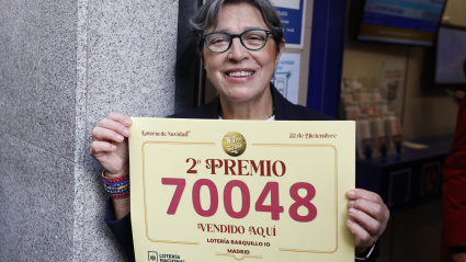 Una trabajadora de la administración de loterías del número 10 de la calle Barquillo, en Madrid, donde se ha vendido íntegramente el 70.048, el segundo premio del Sorteo Extraordinario de la Lotería de Navidad,