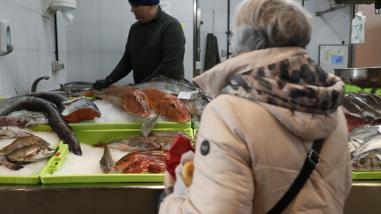 Una consumidora compra pescado en un mercado