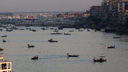 Carga y pasajeros al anochecer en dirección a Sadarghat y el río Buriganga que atraviesa el corazón de Dhaka, Bangladesh.