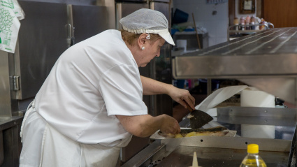 Lola Sánchez, guisandera del Yumay, elaborando un plato en las cocinas de la Sidrería