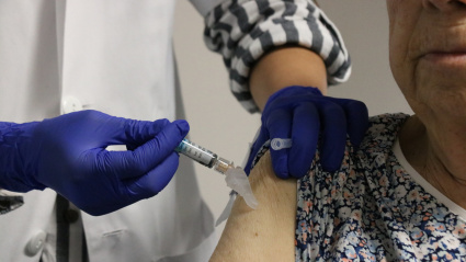 Profesional vacunando de COvid-19 a una