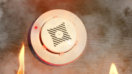 Smoke detector with red alarm indicator during the fire in the building, mounted on the wall, low angle, side view