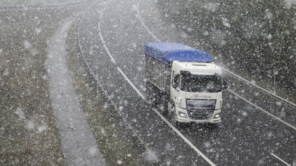Un camión circula este viernes bajo una nevada por la A-67