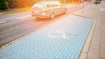 Símbolo internacional para discapacitados pintado en azul brillante en una plaza de aparcamiento