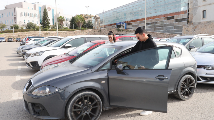 Dos jóvenes compartiendo vehículo en el aparcamiento del Campus Muralla del Mar