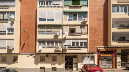 Fachada de edificios de viviendas con terrazas cerradas y locales comerciales en planta baja.