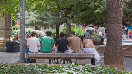 Jóvenes sentados en un banco en un parque en Palma de Mallorca