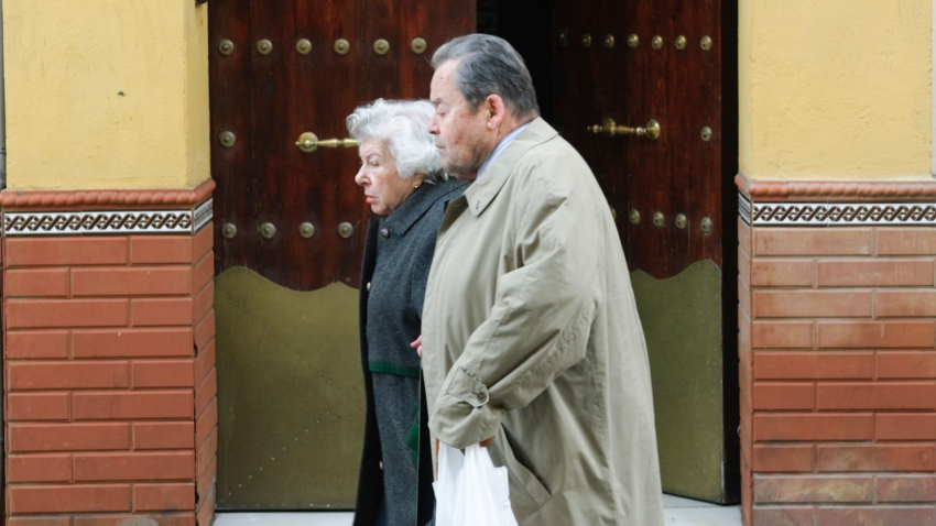 Una pareja de jubilados camina por la calle en Sevilla, Andalucía.