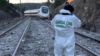 Un agente de la Guardia Civil toma fotografías para la búsqueda de evidencias que puedan servir para la identificación de víctimas e investigación del accidente de trenes cerca de Adamuz