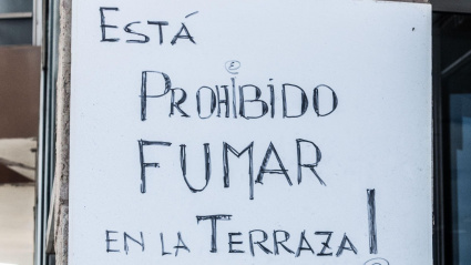 Cartel que prohíbe fumar en la terraza de un bar