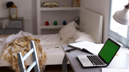 Habitación de adolescente, con portátil en la mesa y cama sin hacer