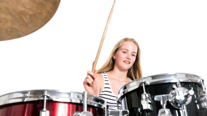 Una niña toca la batería