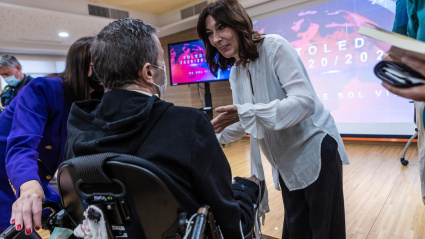 La periodista y expaciente del Hospital Nacional de Parapléjicos (HNP) Sol Villanueva (d) conversa con un asistente mientras presenta su libro 'Toledo 1520-2022'