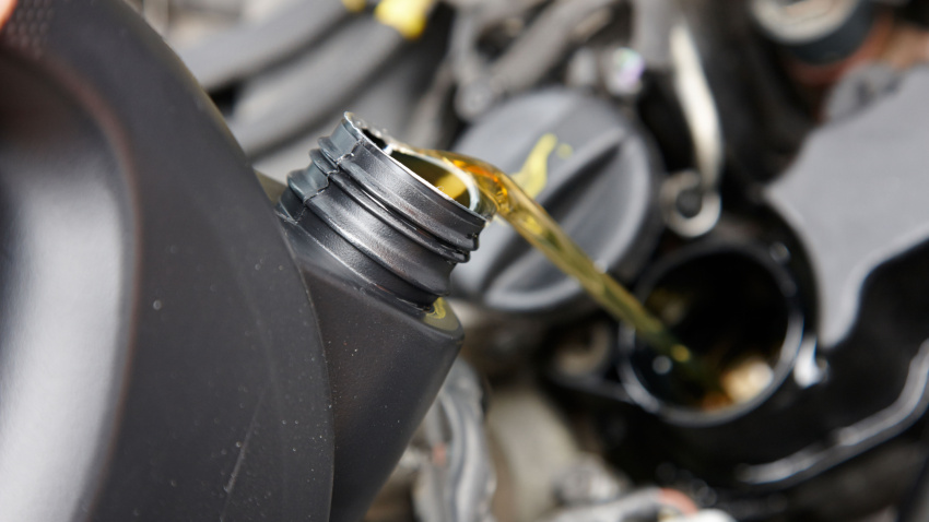 Vierte aceite nuevo en el depósito del motor de un automóvil