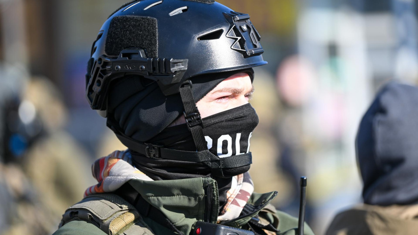 Un oficial federal hace guardia durante los enfrentamientos después de que ICE disparó fatalmente a un hombre varias veces mientras intentaban detenerlo en Minneapolis.