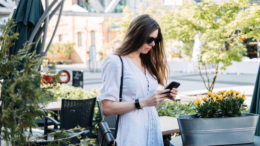 Miedo a perderse algo, ansiedad social, estar conectado constantemente, miedo al arrepentimiento, redes sociales. Mujer revisando su teléfono inteligente y leyendo.