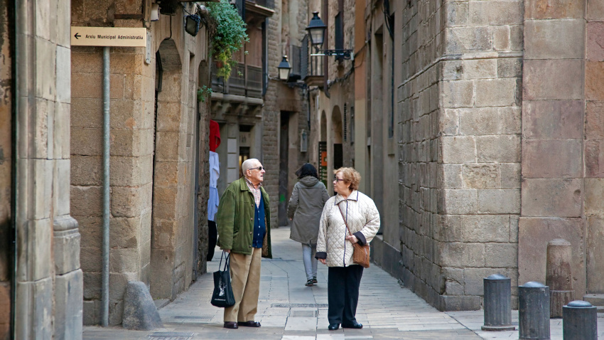 Una pareja de jubilados haciendo compras en un callejón del Barri Gòtic de Barcelona