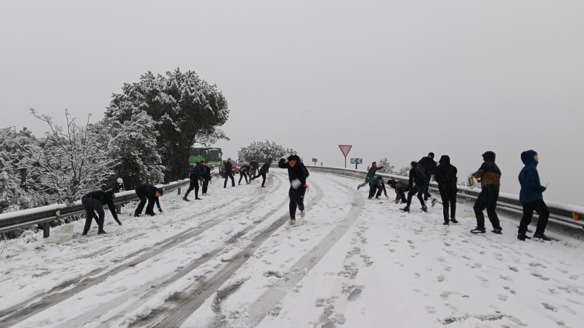 Varias personas se lanzan bolas de nieve en la carretera M-519 a la altura de Galapagar, este miércoles, en el que la borrasca Kristin deja una nevada en la región de Madrid.