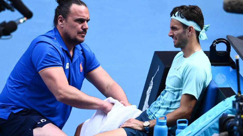 Lorenzo Musetti es atendido por su fisio tras hacerse daño en el partido contra Djokovic.