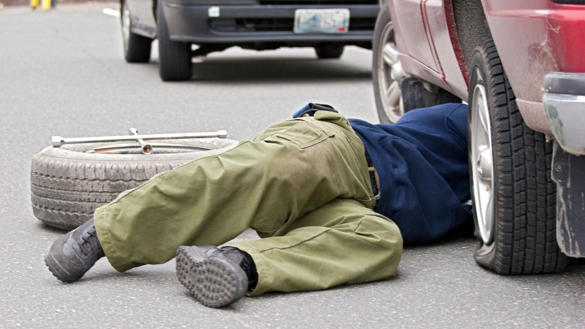 D0HYCD Man fixes a flat tire, flat tyre.
