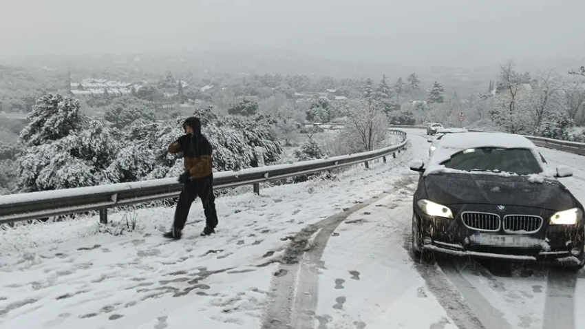 Una persona camina junto a varios vehículos en la carretera M-519 a la altura de Galapagar