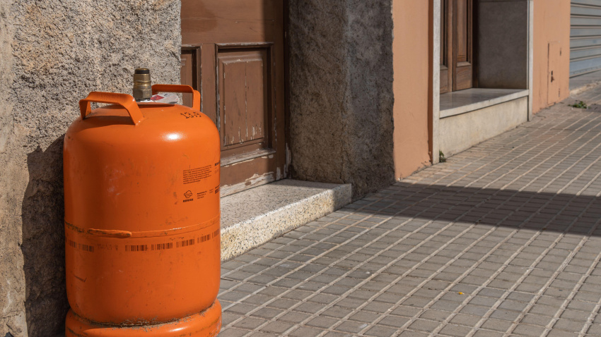 Bombona de butano vacía en la puerta de una casa