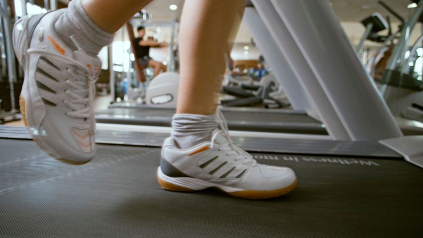Una persona corriendo en una cinta en un gimnasio, imagen de archivo