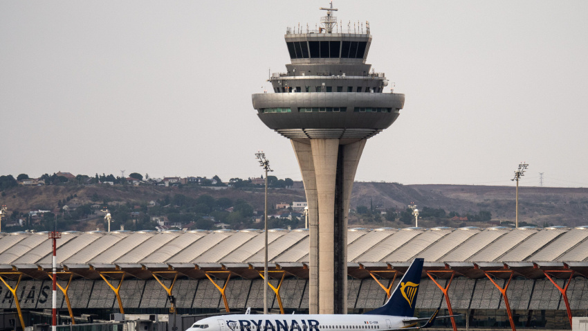 Un avión de Ryanair se ve en la pista del Aeropuerto Adolfo Suárez Madrid Barajas pasando por la torre de control del tráfico aéreo.