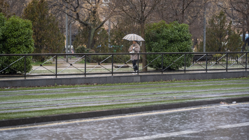 Imágenes de transeúntes por las calles de Granada con el temporal que barre gran parte de Andalucía