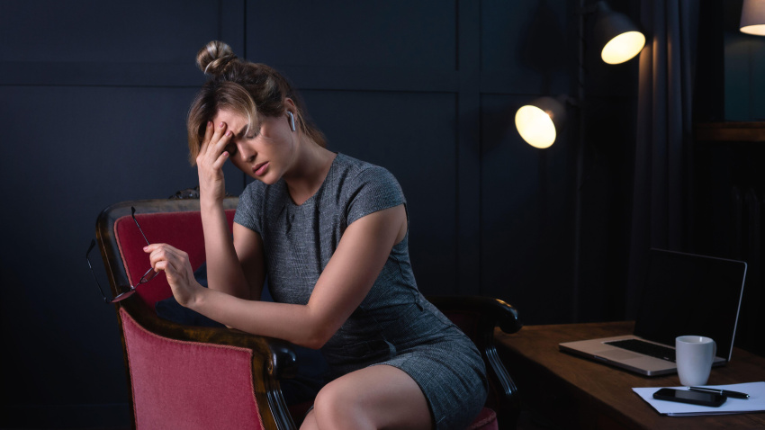 Mujer de negocios cansada con dolor de cabeza durante el trabajo nocturno en la oficina. Concepto de baja laboral