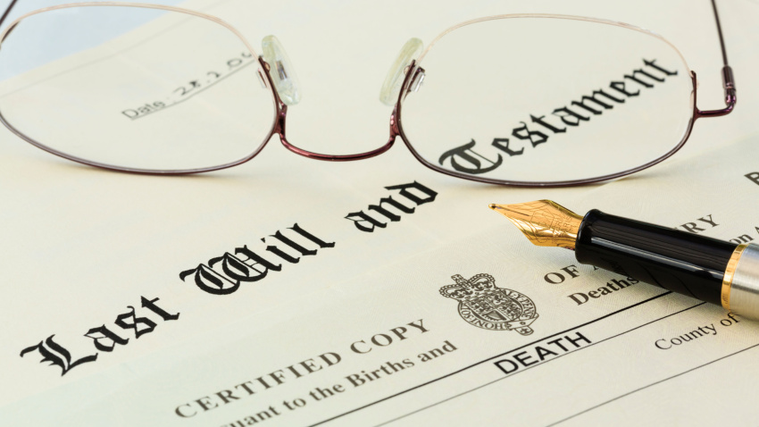 Papel donde se redacta el testamento, junto con unas gafas y una pluma