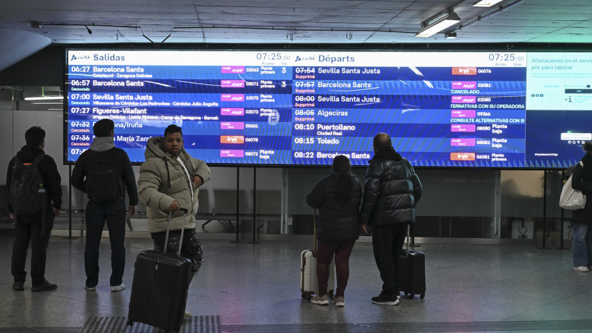 Viajeros afectados por la huelga de trabajadores ferroviarios consultan los horarios de los trenes de alta velocidad en la estación de Atocha de Madrid