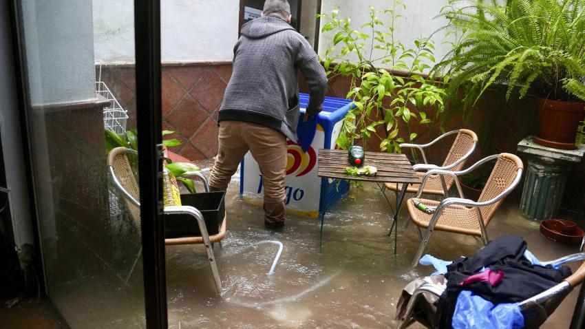 Vecinos de Grazalema (Cádiz) intentan achicar agua de sus casa y locales inundados por las intensas lluvias