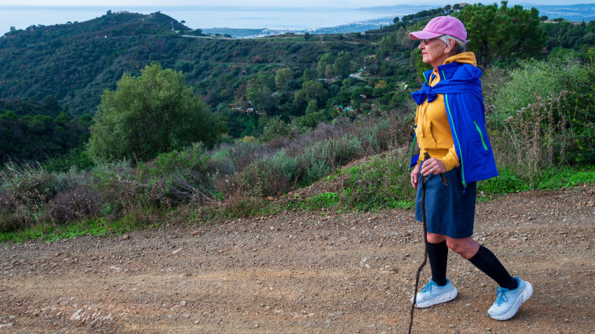 Una mujer jubilada camina por los numerosos senderos en las montañas sobre Estepona