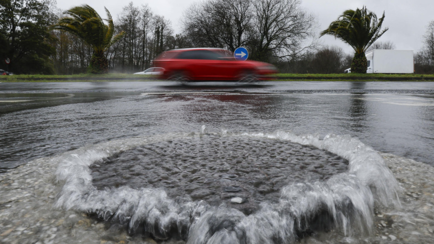 Una alcantarilla rebosa debido a las continuas lluvias de la borrasca Nils, hoy miércoles en Santiago de Compostela