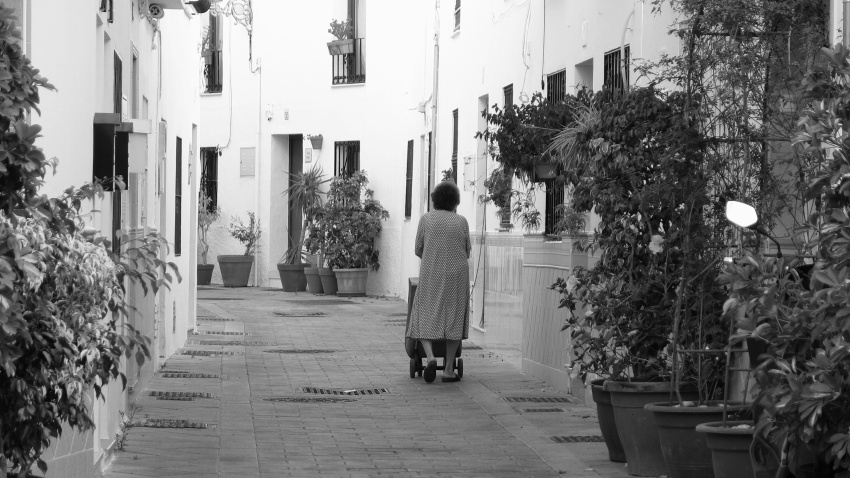 Una jubilada empuja un carrito de la compra camino a casa. Benalmádena Pueblo, Málaga.