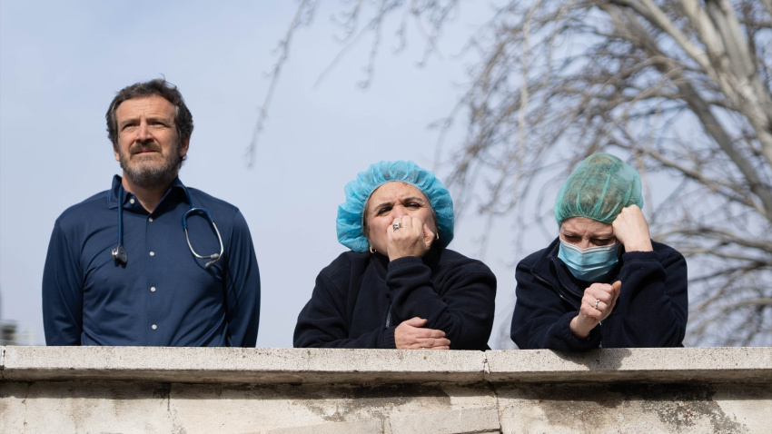 Tres sanitarios observan la concentración, frente al Hospital Gregorio Marañón, en la primera jornada de huelga general del sector médico